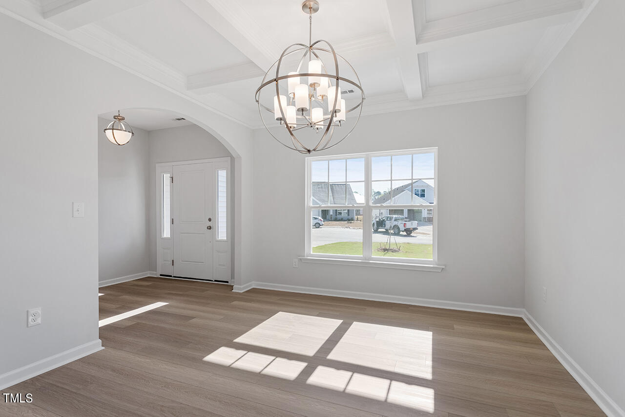 63 Beech Tree Way, Unit 139 Garner, NC 27529 - Photo 14 of 25 an empty room with wooden floor fan and windows