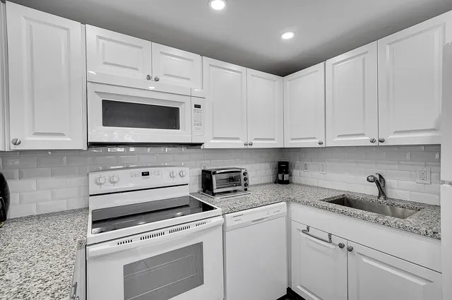 a kitchen with white cabinets and white appliances