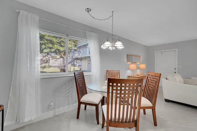 a view of a dining room with furniture a chandelier and window