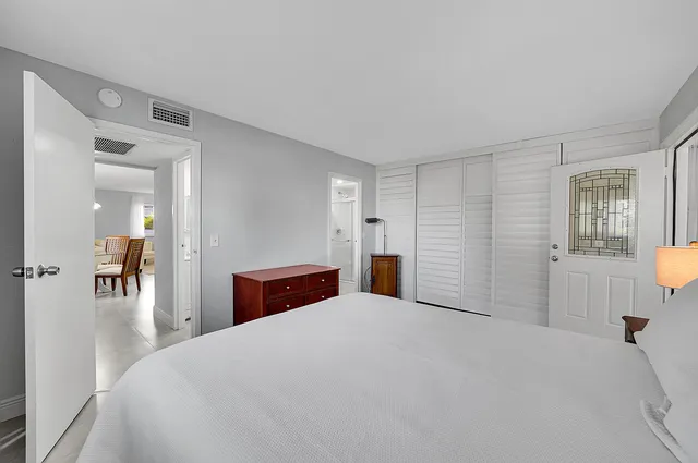 a bedroom with a large bed and wooden floor