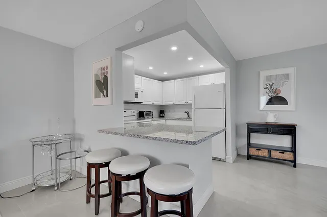 a kitchen with stainless steel appliances granite countertop a sink and a refrigerator