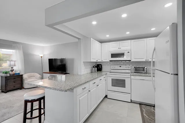a kitchen with appliances a sink and cabinets
