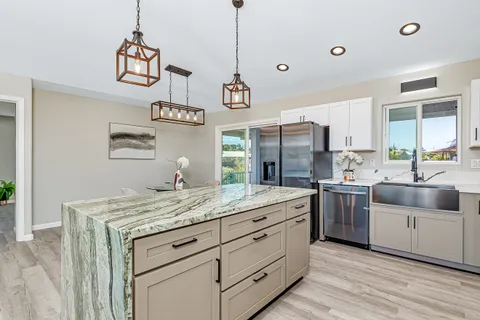 a kitchen with a sink dishwasher a stove and a refrigerator with wooden floor