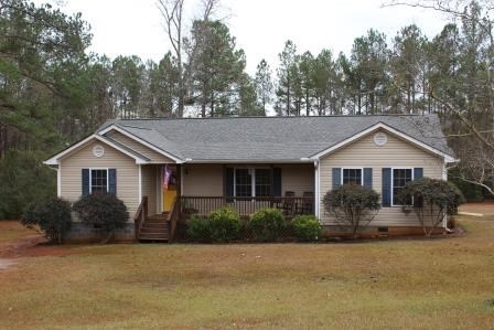 222 Reedy Creek Road Forsyth, GA 31029 - Photo 1 of 15 a front view of house with yard and trees in the background