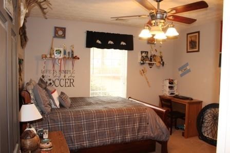222 Reedy Creek Road Forsyth, GA 31029 - Photo 10 of 15 a bedroom with a bed and a chandelier