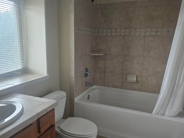 a white bath tub sitting next to a white toilet