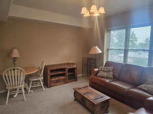 a living room with furniture a chandelier and a window