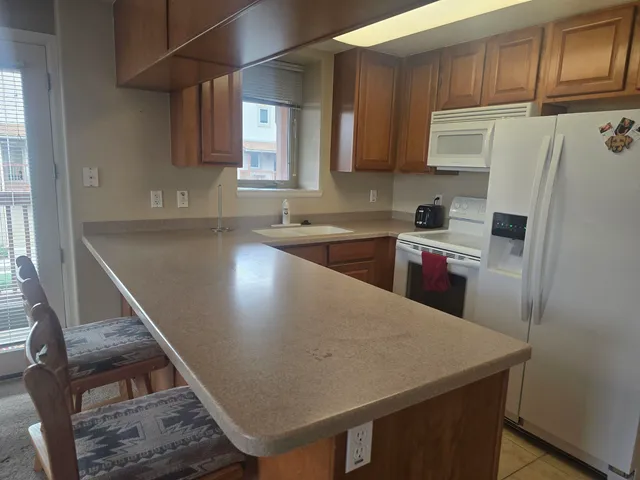 a kitchen with granite countertop a sink a stove and refrigerator