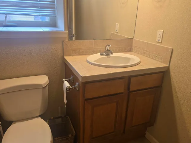 a bathroom with a toilet sink and mirror
