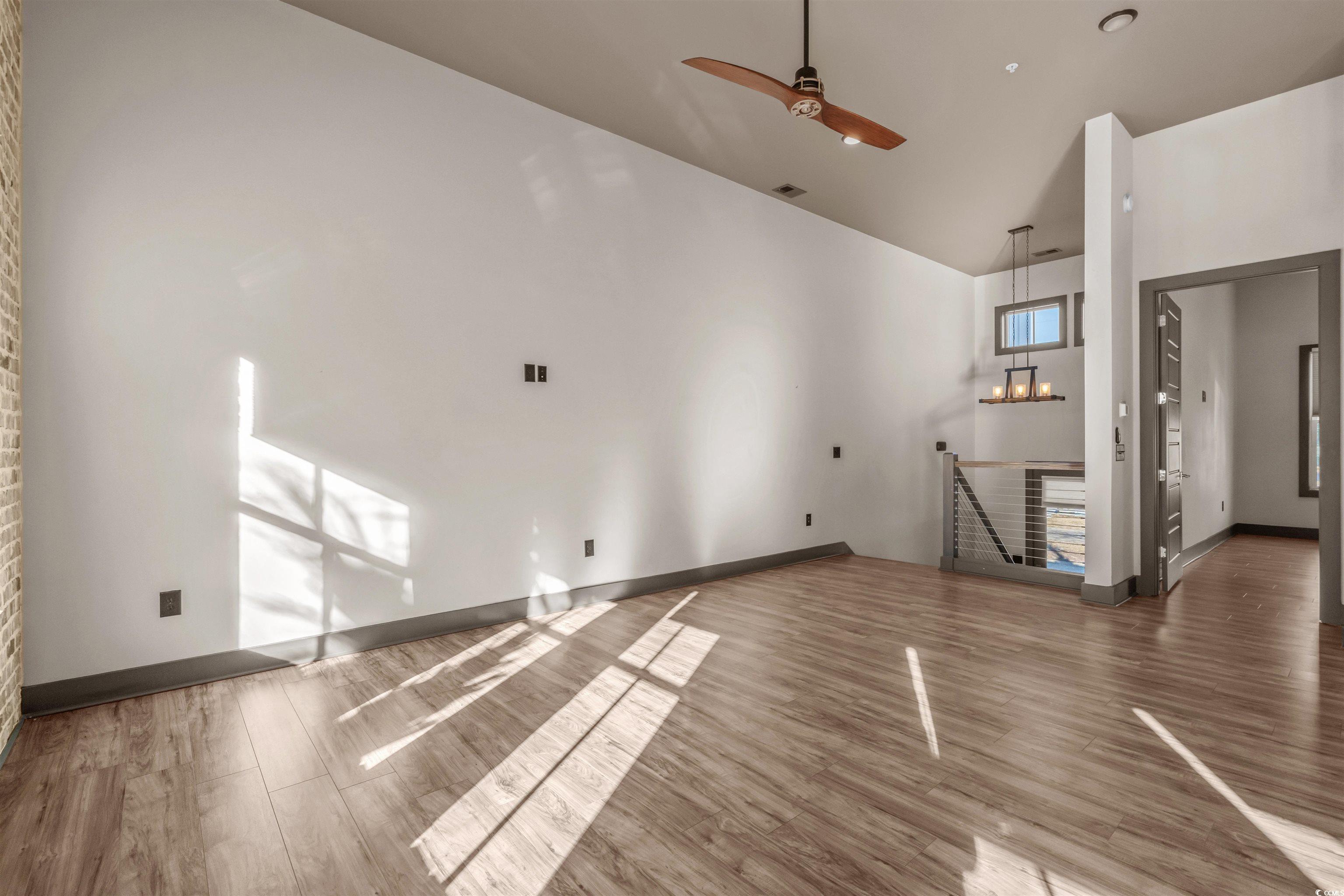 80 Shady Oak Lane Murrells Inlet, SC 29576 - Photo 6 of 31 Unfurnished living room with wood finished floors, high vaulted ceiling, and ceiling fan