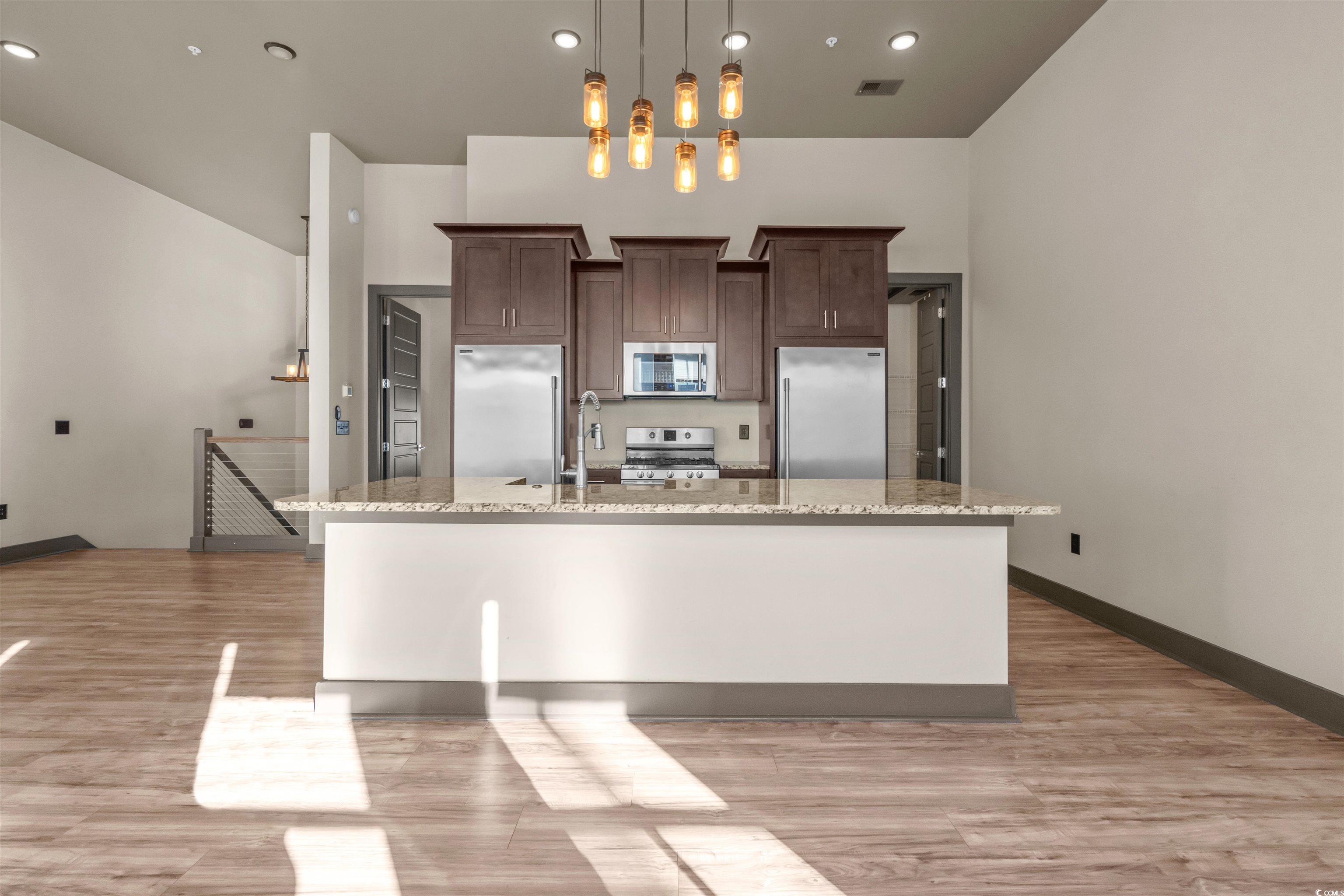 80 Shady Oak Lane Murrells Inlet, SC 29576 - Photo 8 of 31 Kitchen featuring a center island with sink, stainless steel appliances, dark brown cabinetry, light stone countertops, and recessed lighting