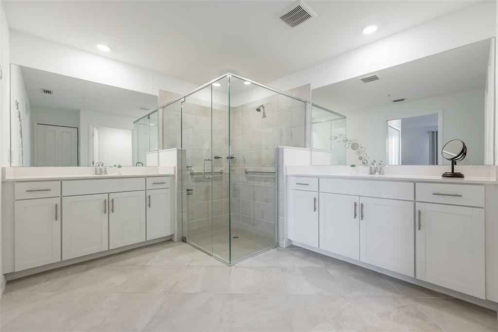 14186 Poppy Fld Loop, Unit 4911 Punta Gorda, FL 33955 - Photo 24 of 48 a spacious bathroom with a shower a sink a mirror and a vanity