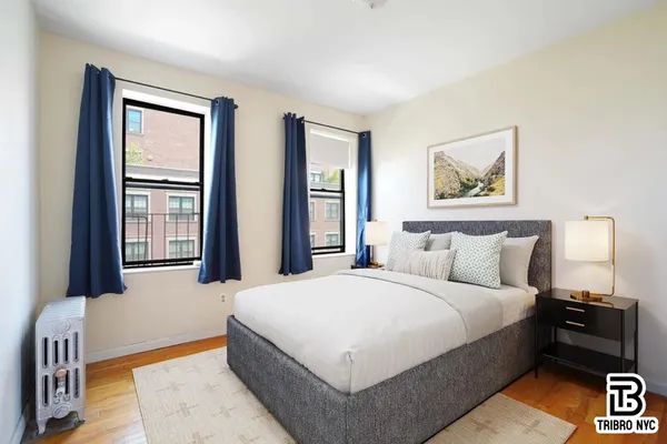 a large bedroom with a bed and wooden floor