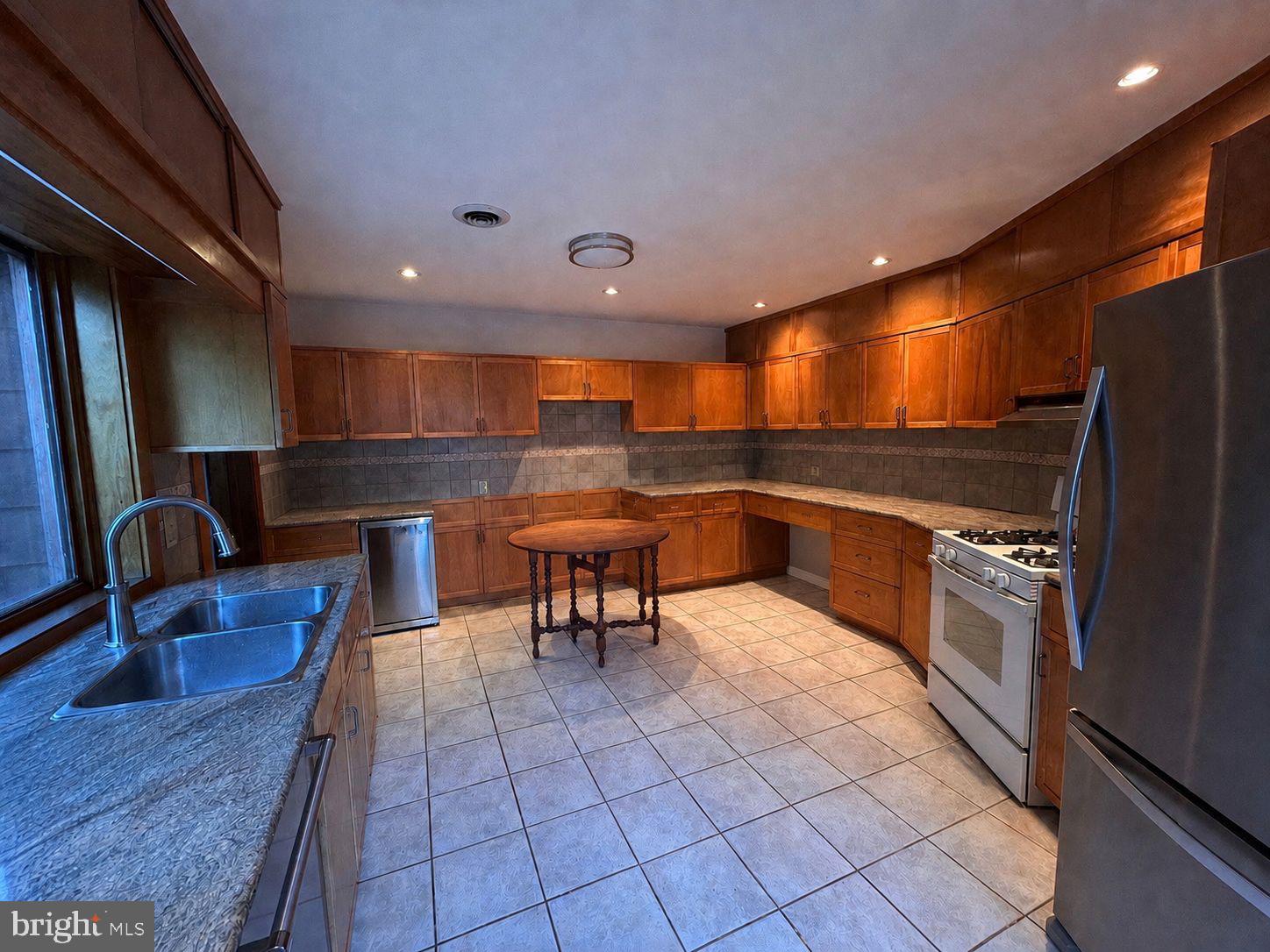 8204 Brookside Road Elkins Park, PA 19027 - Photo 6 of 20 a kitchen with stainless steel appliances dining table and chairs