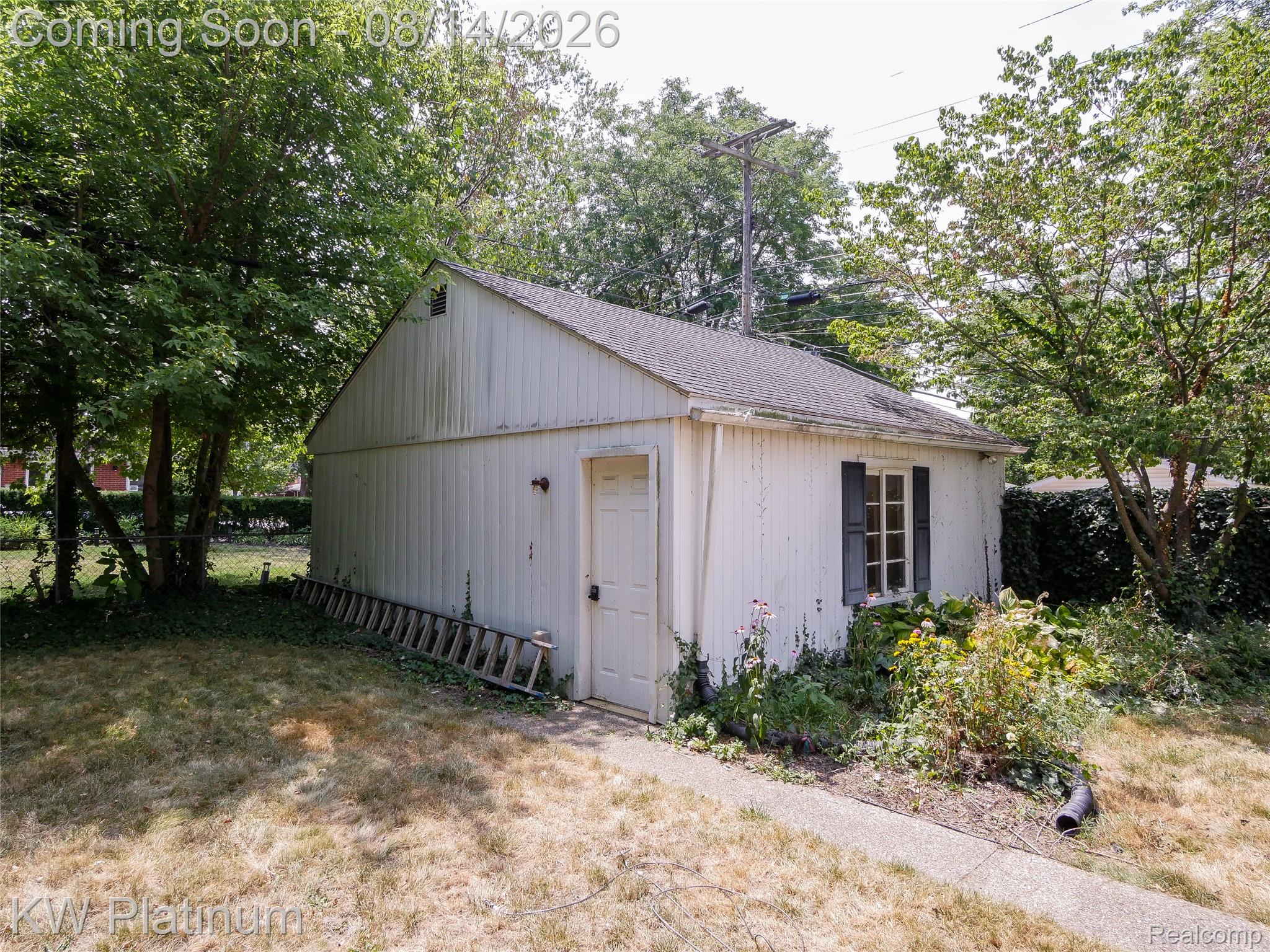 657 Hawthorne Road Grosse Pointe, MI 48236 - Photo 24 of 28 Detached structure featuring a side entry door, a window with dark shutters, and a sloped roof