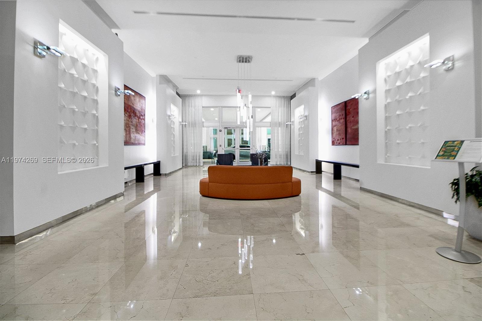 9066 Southwest 73rd Court, Unit 203 Miami, FL 33156 - Photo 18 of 28 a living room with furniture and a chandelier