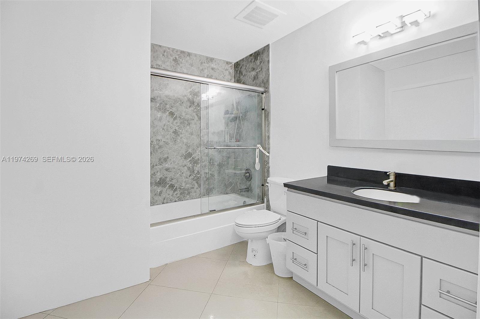 9066 Southwest 73rd Court, Unit 203 Miami, FL 33156 - Photo 7 of 28 a bathroom with a granite countertop sink a toilet and shower