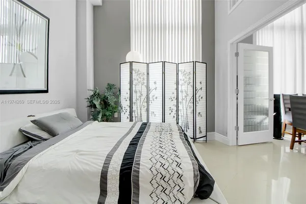 a bedroom with a bed and painting on the wall
