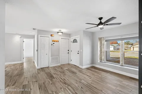 a view of a livingroom with wooden floor and ceiling fan