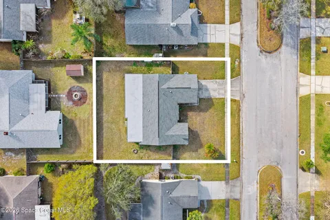 an aerial view of residential houses with outdoor space and trees