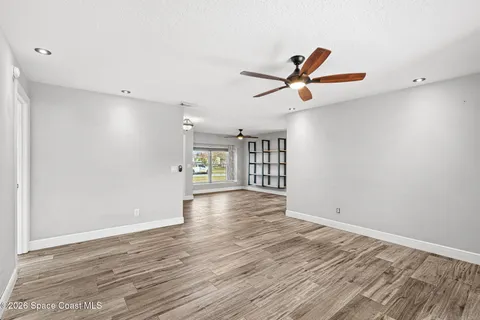 a view of a livingroom with a hardwood floor and a ceiling fan