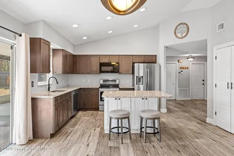 a large kitchen with stainless steel appliances lots of counter space and wooden floor