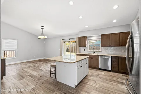 a large kitchen with stainless steel appliances granite countertop a stove oven and a sink