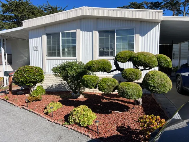 a front view of a house with a yard and outdoor seating