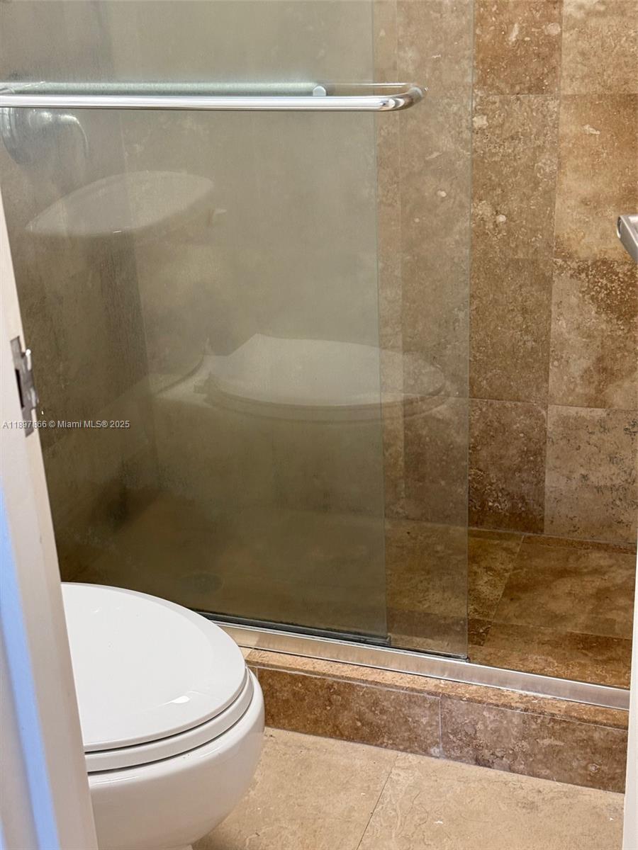 5701 Collins Avenue, Unit 1207 Miami Beach, FL 33140 - Photo 14 of 44 a bathroom with a white toilet and a shower