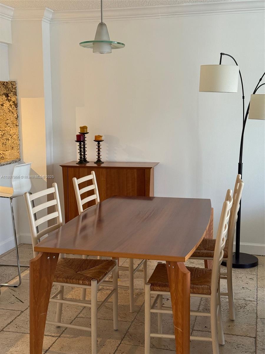 5701 Collins Avenue, Unit 1207 Miami Beach, FL 33140 - Photo 17 of 44 a view of a dining room with furniture and wooden floor
