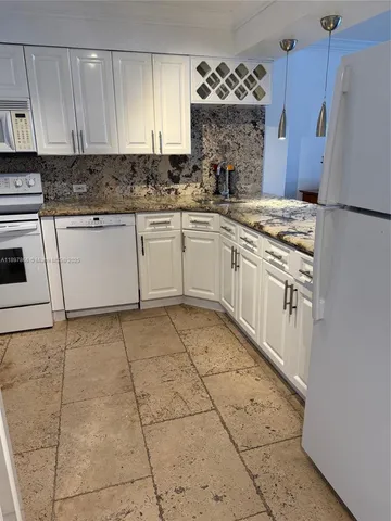 a kitchen with a stove a sink and a refrigerator