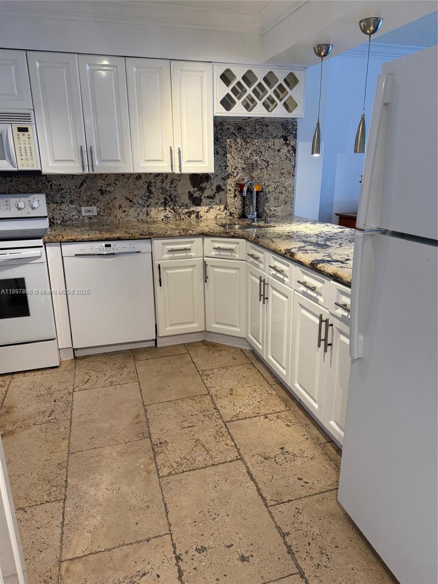 5701 Collins Avenue, Unit 1207 Miami Beach, FL 33140 - Photo 5 of 44 a kitchen with a stove a sink and a refrigerator