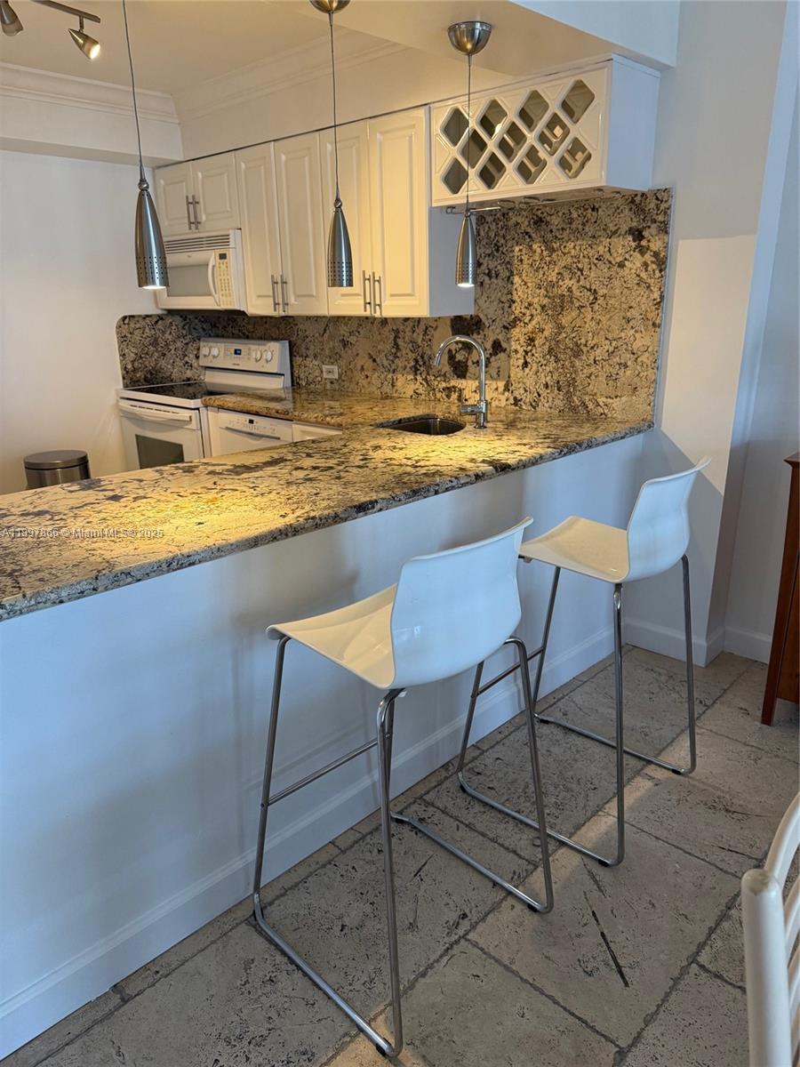 5701 Collins Avenue, Unit 1207 Miami Beach, FL 33140 - Photo 7 of 44 a view of a kitchen with kitchen island stainless steel appliances granite countertop a sink and a refrigerator
