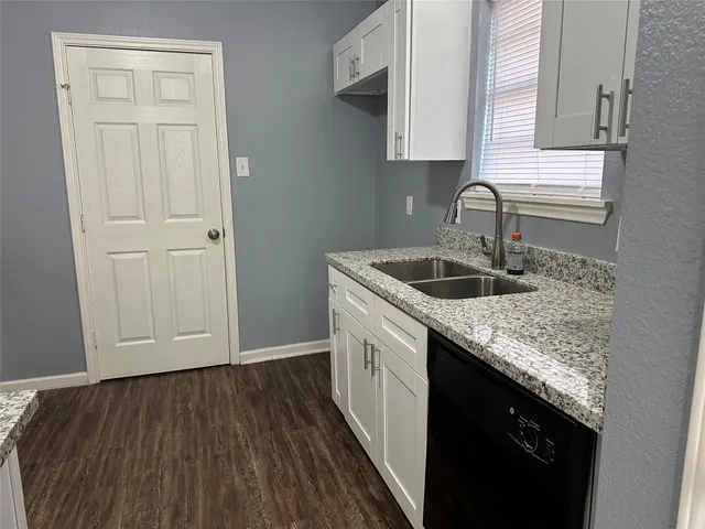 a kitchen with granite countertop cabinets sink and dishwasher