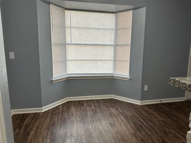 a room view with wooden floor and windows