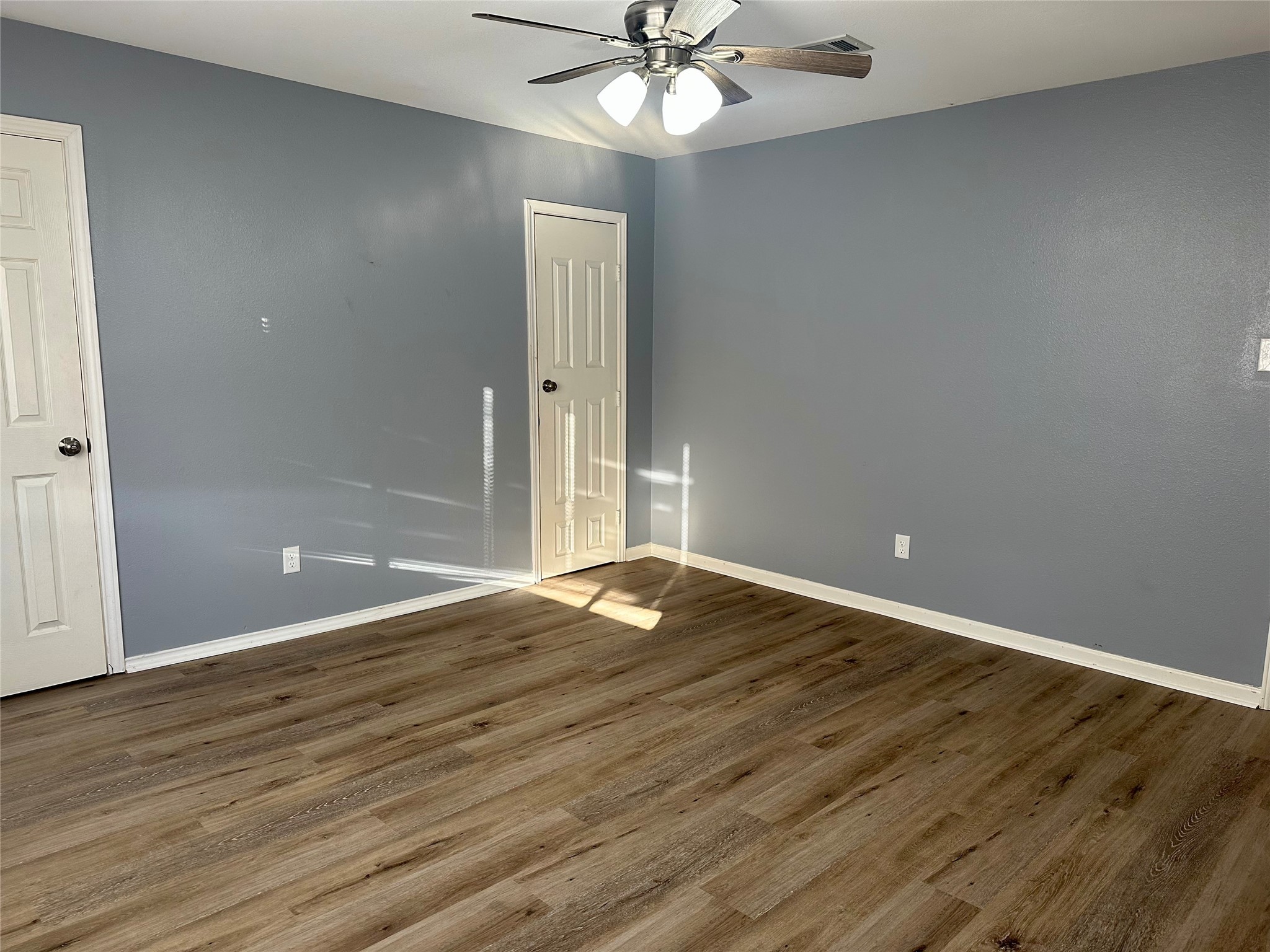 15770 Chimney Rock Road Houston, TX 77489 - Photo 29 of 42 a view of an empty room with wooden floor and a ceiling fan