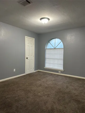 an empty room with a window and a ceiling fan