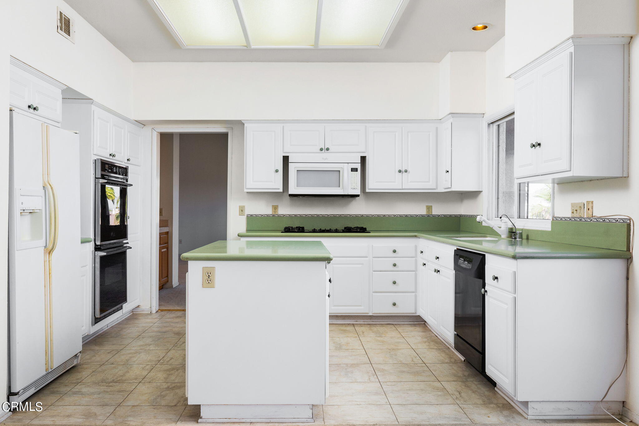 4212 Harbour Island Lane Oxnard, CA 93035 - Photo 23 of 48 a kitchen with granite countertop white cabinets and refrigerator