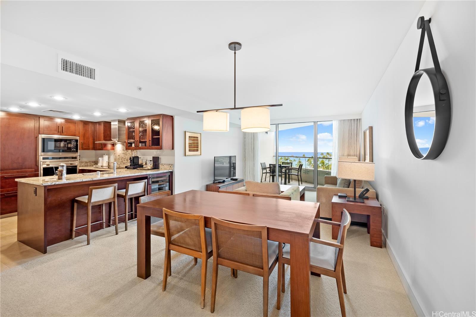 a dining room with stainless steel appliances granite countertop a table chairs and a kitchen view