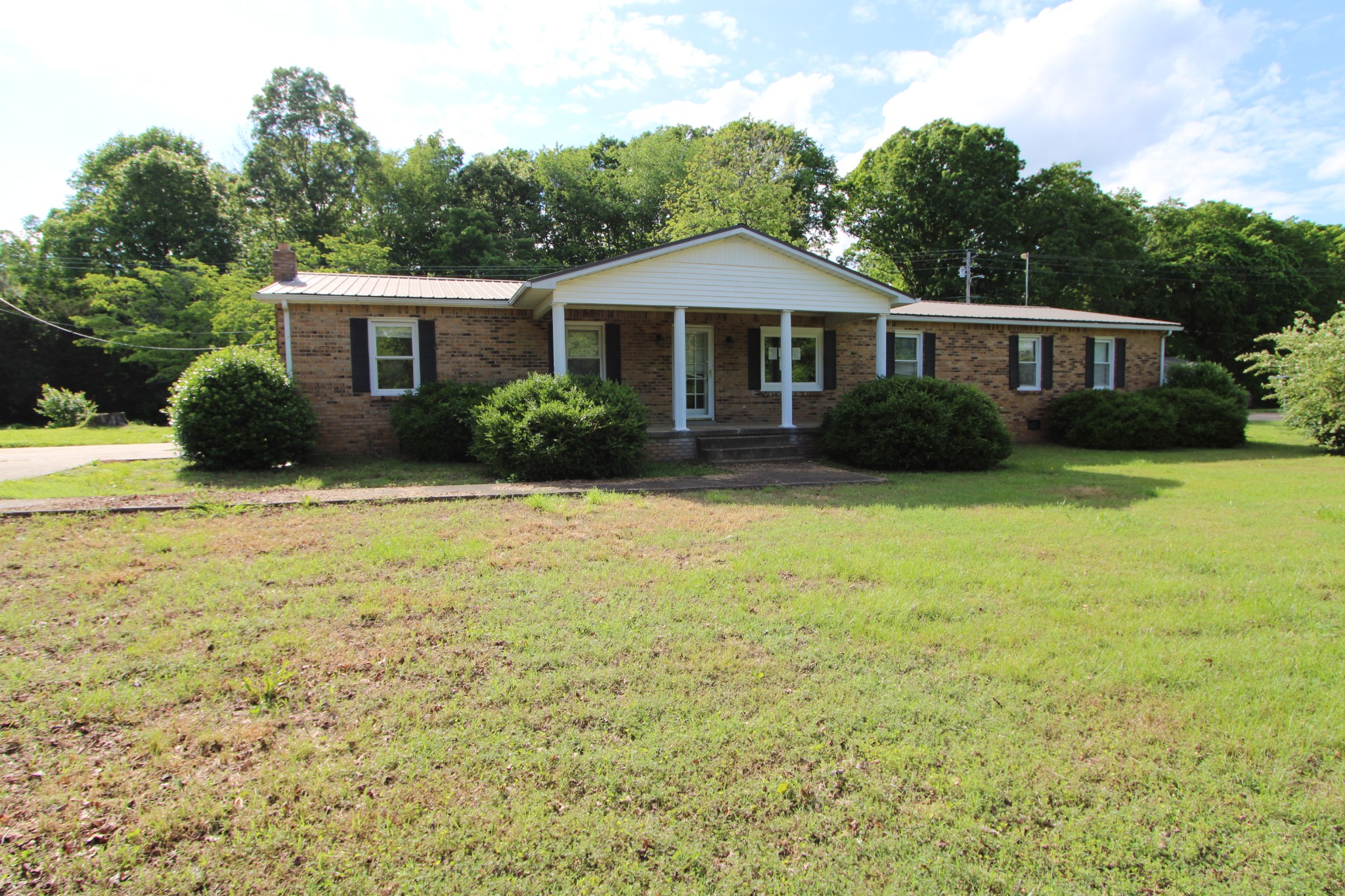 a front view of a house with yard and green space
