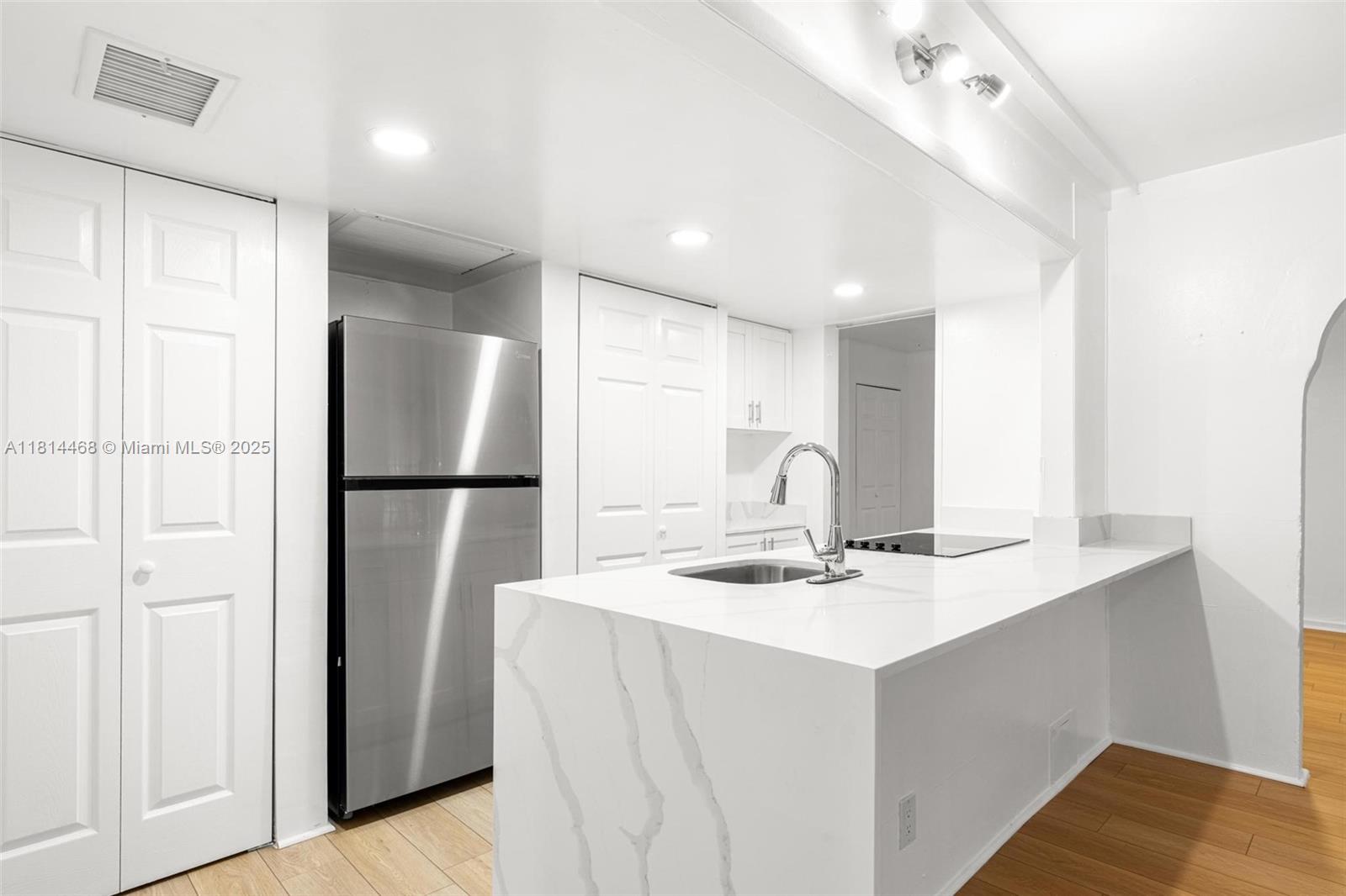 15007 Coconut Court Miami Lakes, FL 33014 - Photo 13 of 27 a kitchen with stainless steel appliances kitchen island a refrigerator sink and cabinets