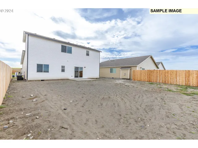 a kitchen with stainless steel appliances kitchen island granite countertop a refrigerator a stove a sink and a wooden floor