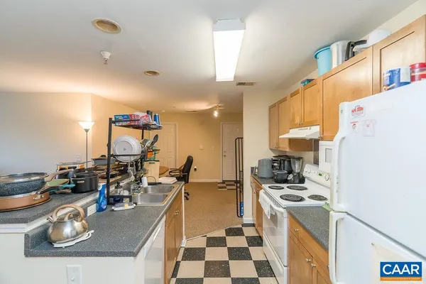 a kitchen with a refrigerator a stove a sink and cabinets