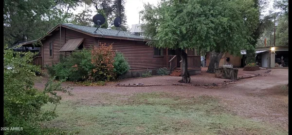 a view of a house with a yard and large tree