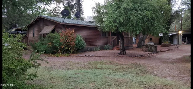 a view of a house with a yard and large tree