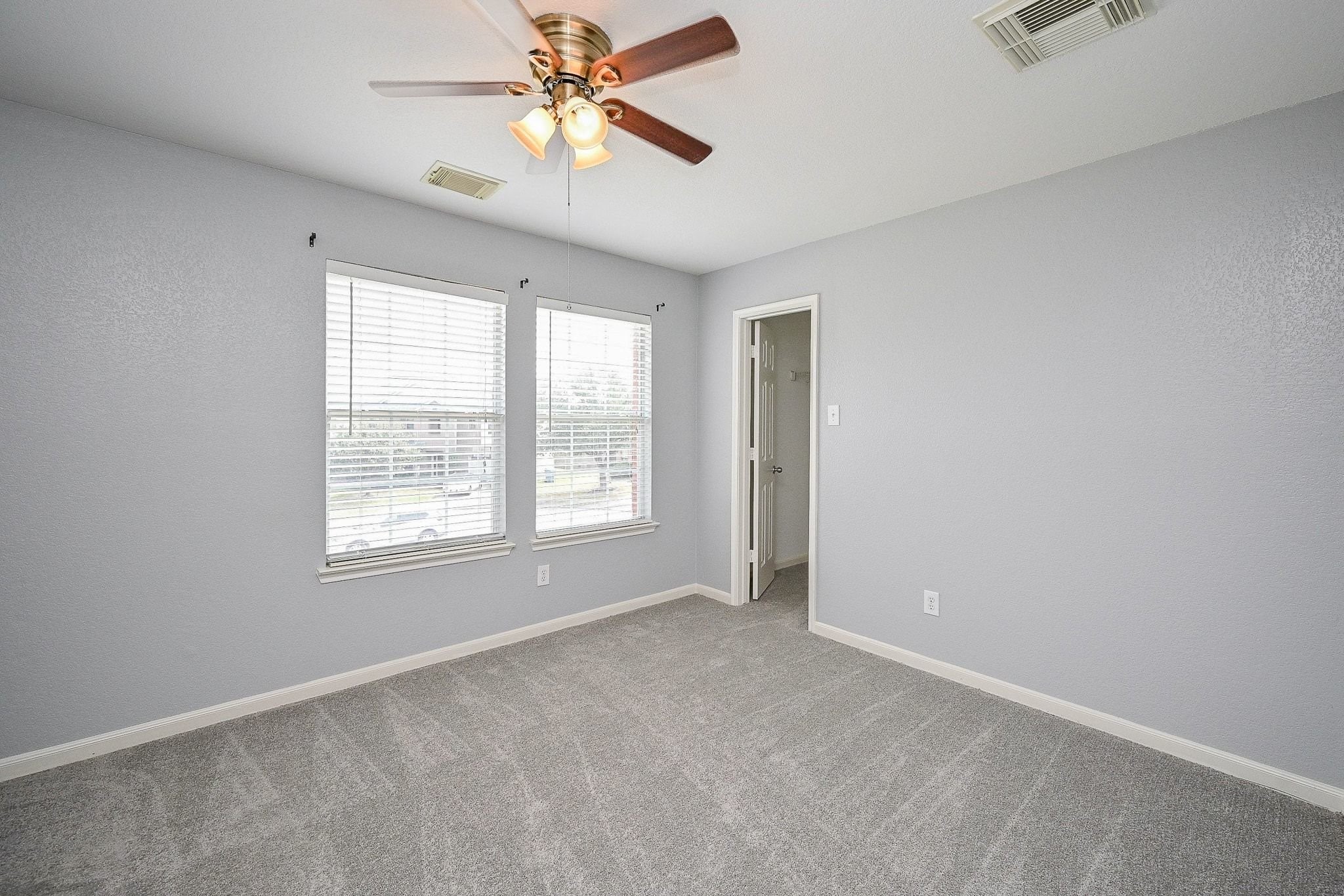 6638 Autumn Sunset Lane Spring, TX 77379 - Photo 26 of 32 Cozy and bright bedroom featuring soft carpeting, ample natural light, and a ceiling fan for comfort. Ideal for relaxation or a home office.