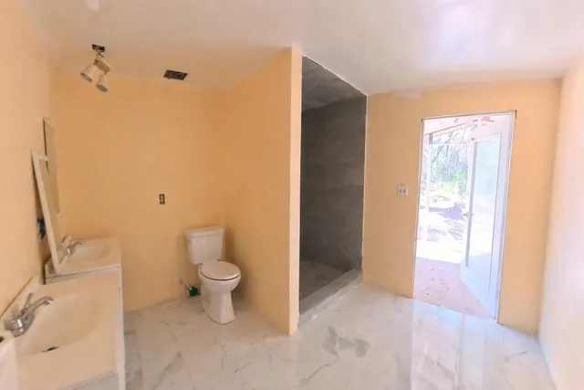 an empty room with closet and a chandelier fan