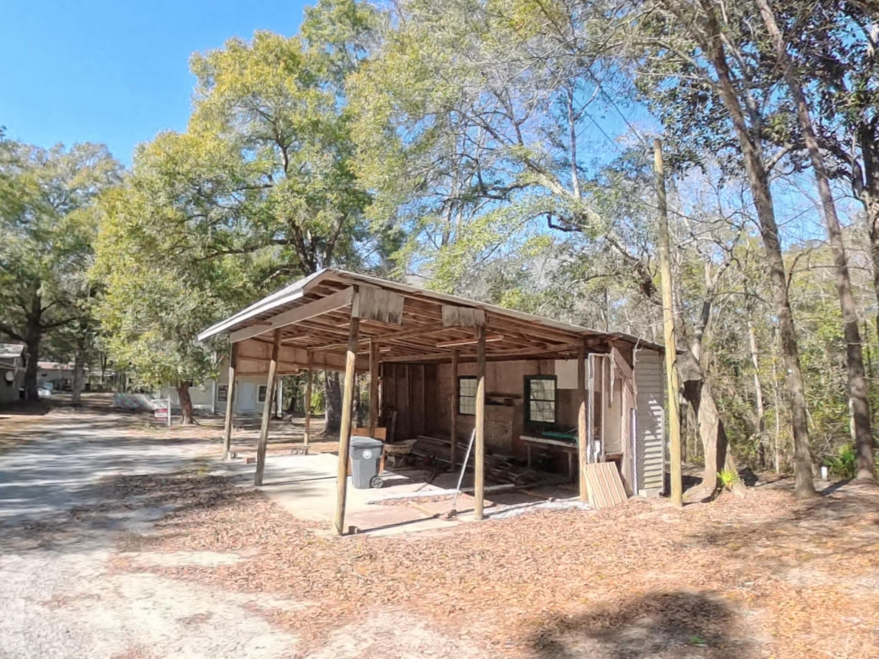78 April Court Freeport, FL 32439 - Photo 37 of 39 a patio with a table and chairs and a large tree