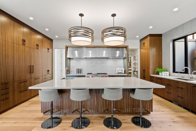 a living room with furniture a flat screen tv and kitchen view
