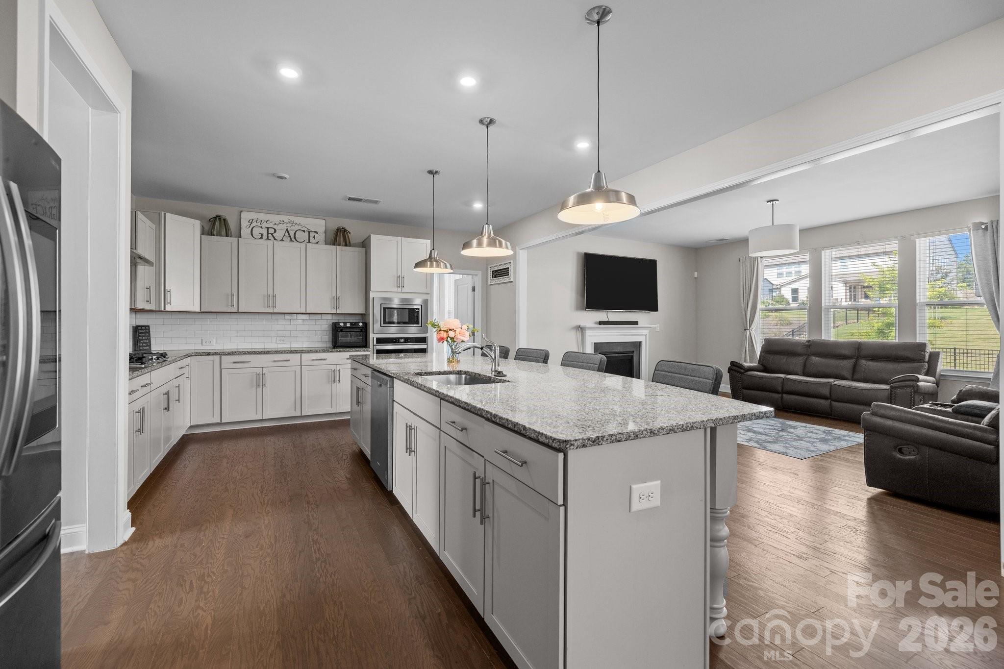 241 Boxelder Road Clover, SC 29710 - Photo 11 of 35 a large kitchen with stainless steel appliances kitchen island granite countertop a stove top oven a sink dishwasher a refrigerator and white cabinets with wooden floor